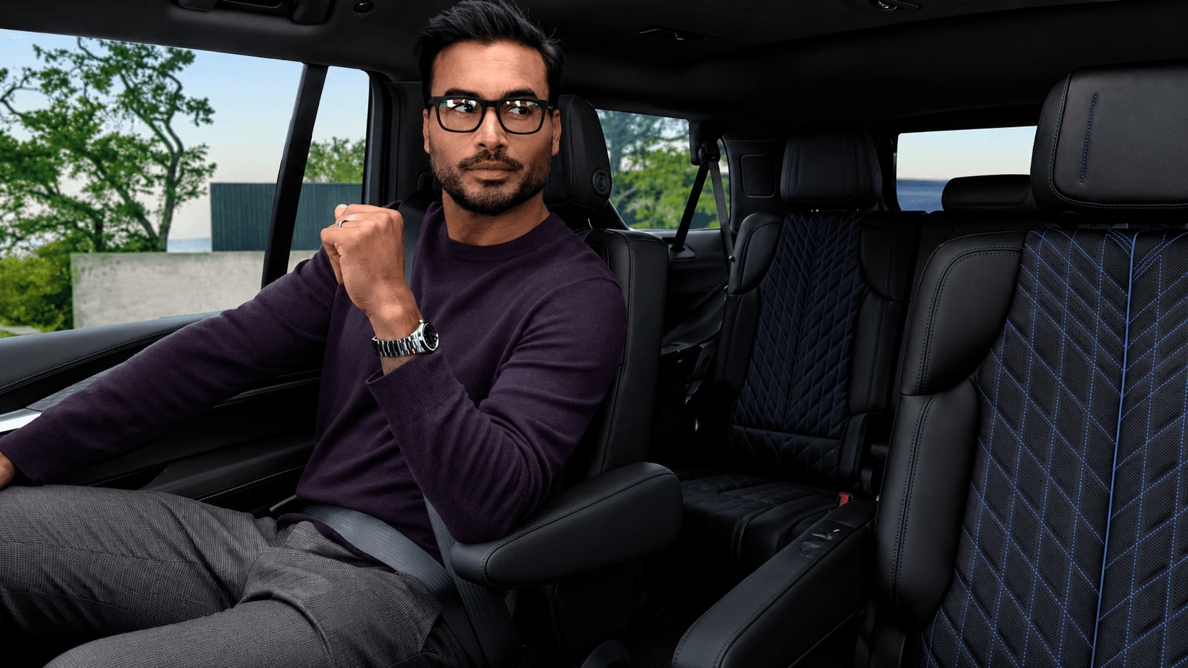 Luxury chauffeur assisting clients near a premium vehicle